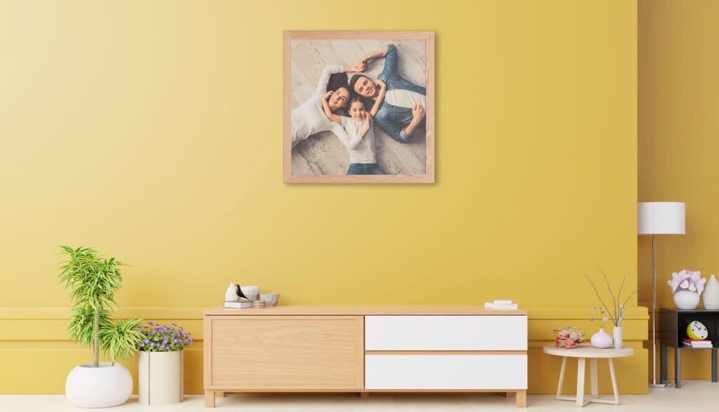 Family Photographer A living room with yellow walls and a picture with an intricate frame design hanging on the wall.